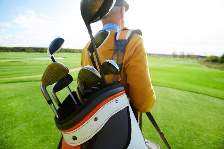 Mature golfer carrying his clubs